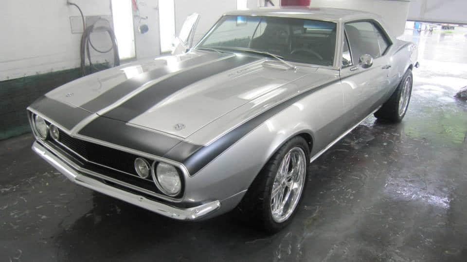Muscle car in paint booth showing finished custom paint job