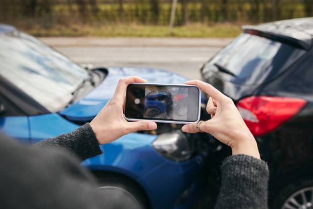 someone taking cell phone pic of car accident